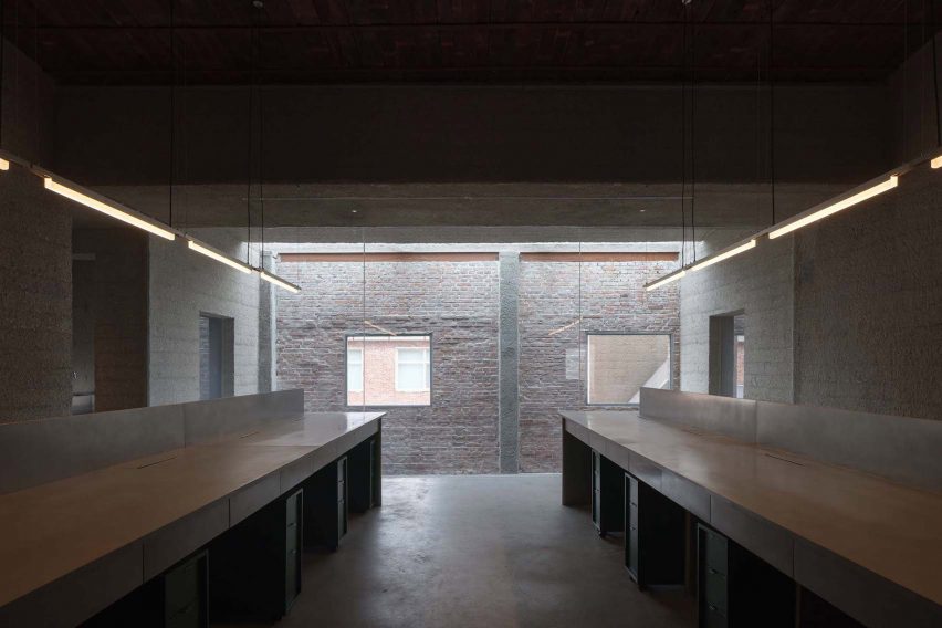 Built-in desks in room with brick walls