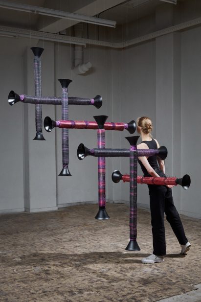 Audience member listens to a speaker within the Re-Sounding Yarn installation by Paula Vogels