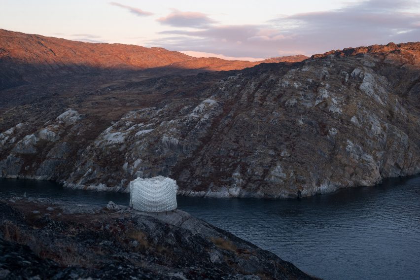 Pavilion by Konstantin Arkitekter on a rocky hillside overlooking a lake