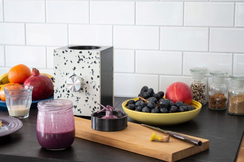 Base of the Re:Mix kitchen mixer on a kitchen bench surrounded by fruit