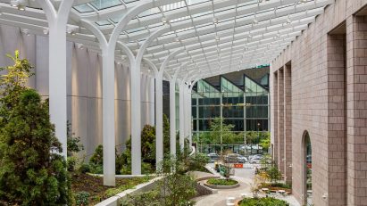 Courtyard with greenery and glazed canopy supported by white columns