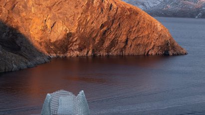 Qaammat by Konstantin Arkitekter on a rocky landscape overlooking a lake