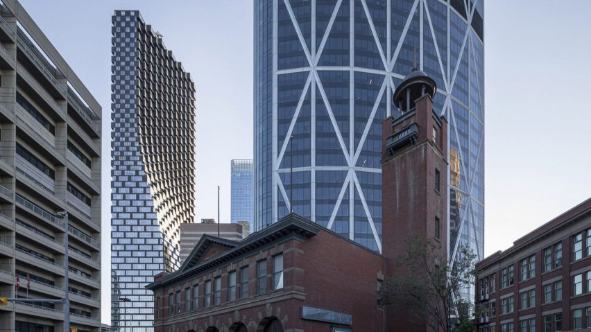 Curving tower in view behind traditional low brick building