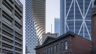Curving tower in view behind traditional low brick building