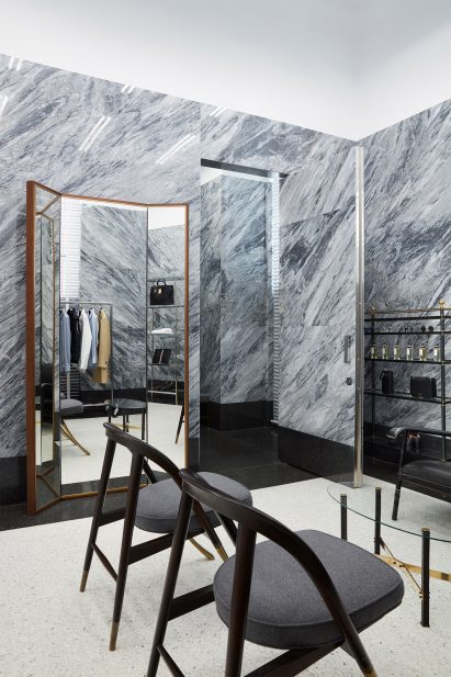 Chairs in front of a mirror and open fitting room door
