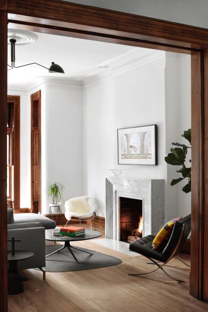 Living room with tall ceilings, white walls, and dark wood trims