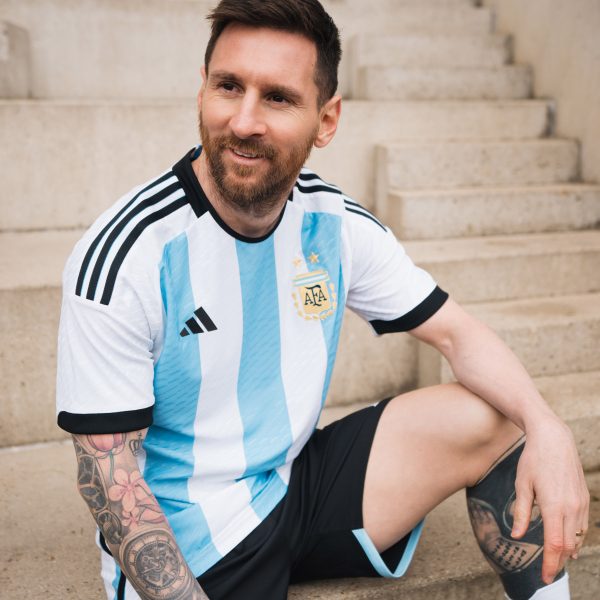 A footballer wearing a white and blue shirt
