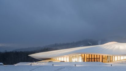 White conference centre with overhanging roof on white snow