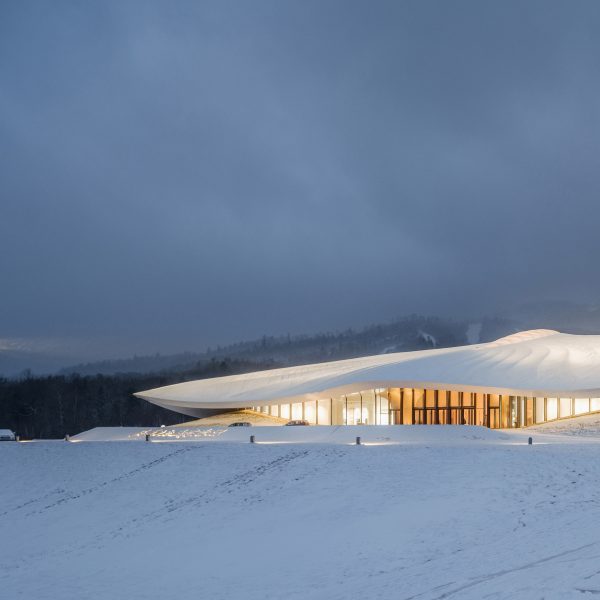 White conference centre with overhanging roof on white snow