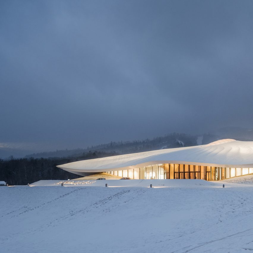 White conference centre with overhanging roof on white snow