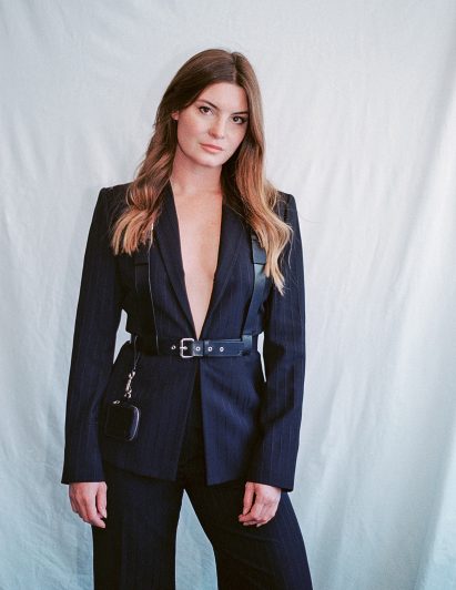 A designer wearing suit and leather harness