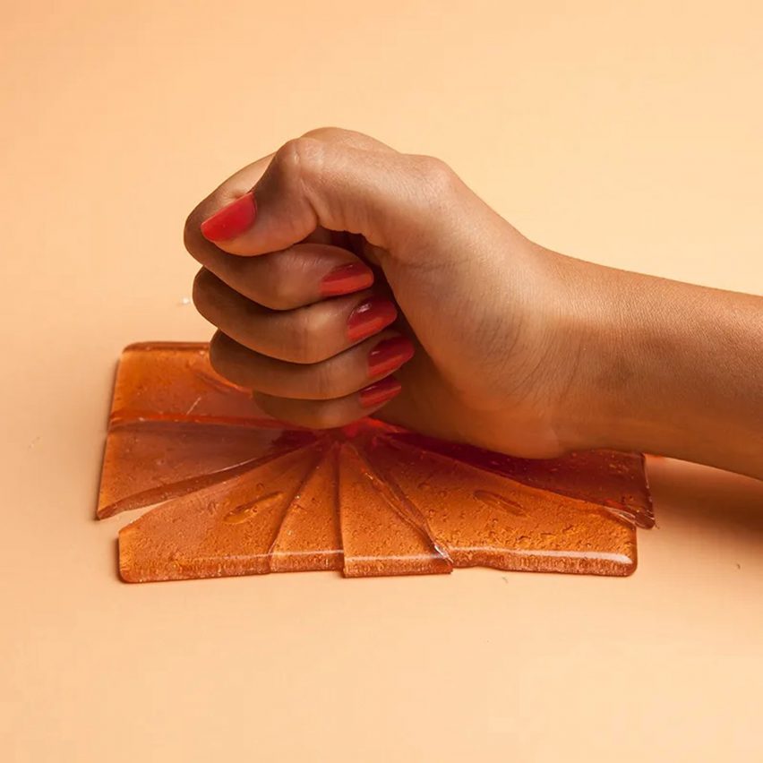 Fist hitting gel pad on orange background