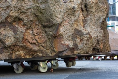 miniature figure holding up boulder dolley at Mike Hewson's Rocks on Wheels playground sculpture in Melbourne