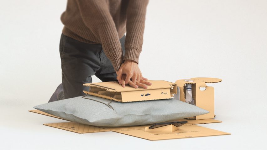 Person pressing down on cardboard packaging and a pillow