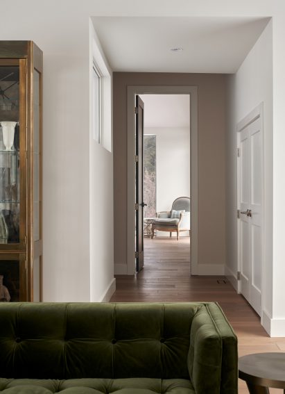 Living room with hallway framing a lounge chair