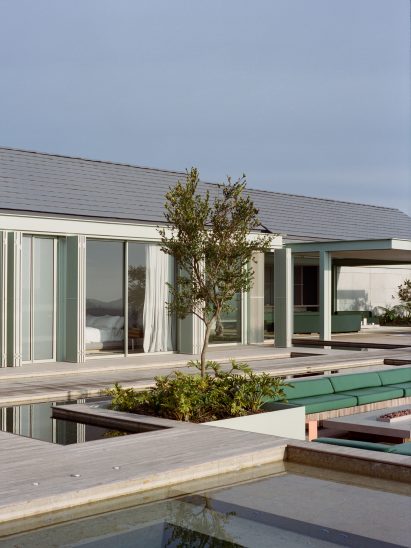 Pool with gabled home and green accents