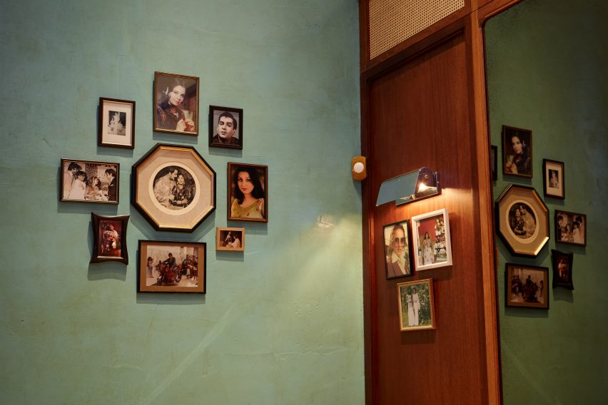 Teal wall with framed photos in Dishoom Canary Wharf