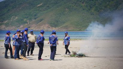 Rangers in Australia standing around a small fire