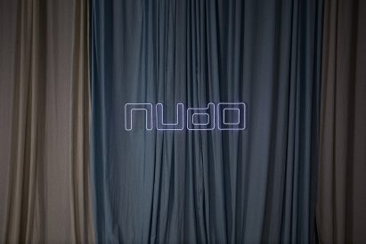 Nudo sign in front of draped fabrics