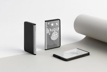 Three Ledger Stax devices at different angles, one showing a Bored Ape NFT in greyscale
