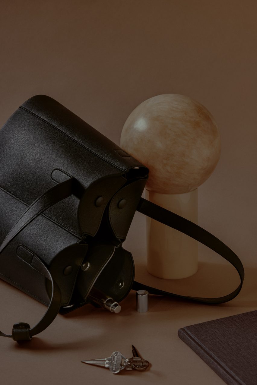 Photo of a black tote bag on its side with objects spilling out of the pockets
