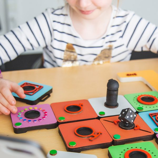 Child playing with a colourful interactive game on a table