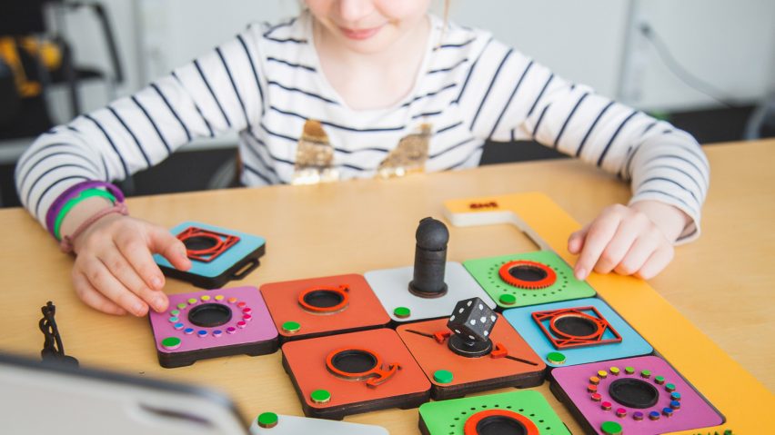 Child playing with a colourful interactive game on a table