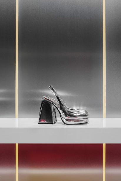 Silver heel on white shelf