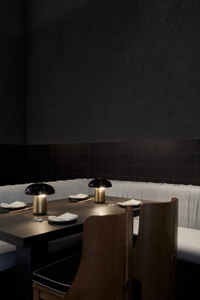 Wooden dining table and chairs in a restaurant with white bench seating