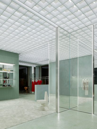 Image of a mint green carpeted area and a Max Lamb chair at the Self-Portrait store