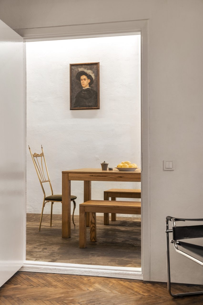 Photograph through doorway of mismatched chairs around a table