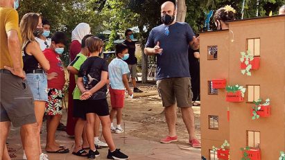 People gathered outside around a model of a building