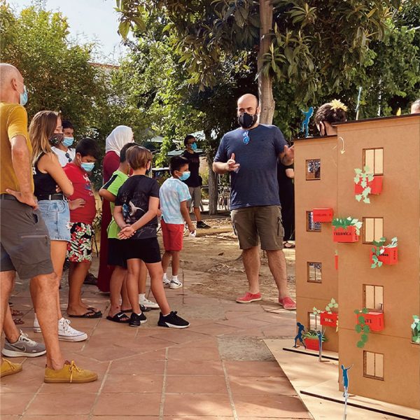 People gathered outside around a model of a building