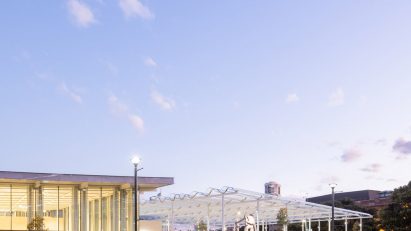 Glass entrance pavilion of Sydney Modern under a clear sky at dusk