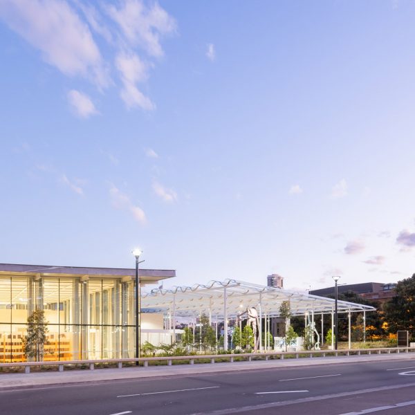 Glass entrance pavilion of Sydney Modern under a clear sky at dusk