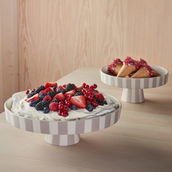 Two bowls on plywood table containing berries and cream
