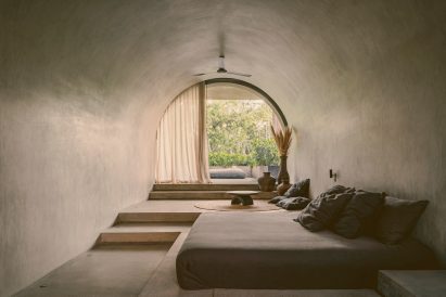 Bedroom with curved ceiling and curved window at end