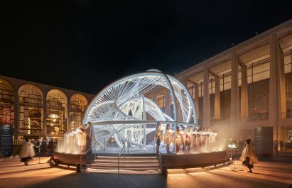 A choir singing in front of a glowing sculpture