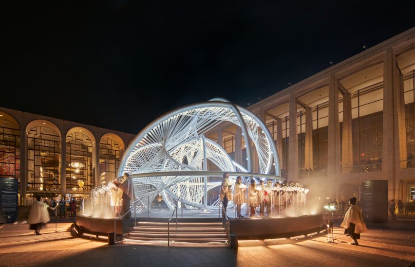 A choir singing in front of a glowing sculpture