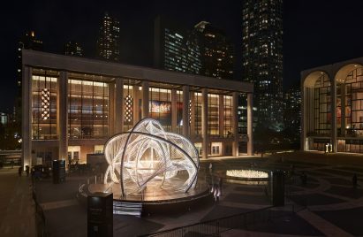 An arched sculpture in the middle of a public plaza