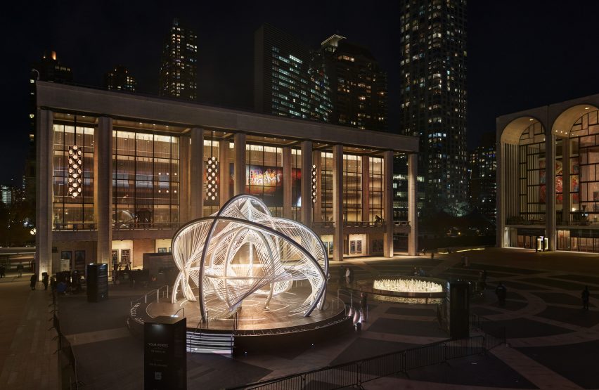 An arched sculpture in the middle of a public plaza