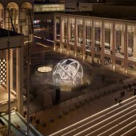 An aerial view of an arched sculpture in a plaza