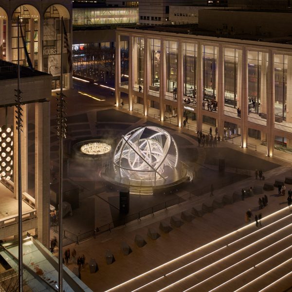 An aerial view of an arched sculpture in a plaza
