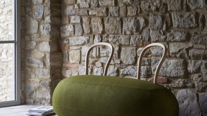 Green pouf-style seat in rustic interior