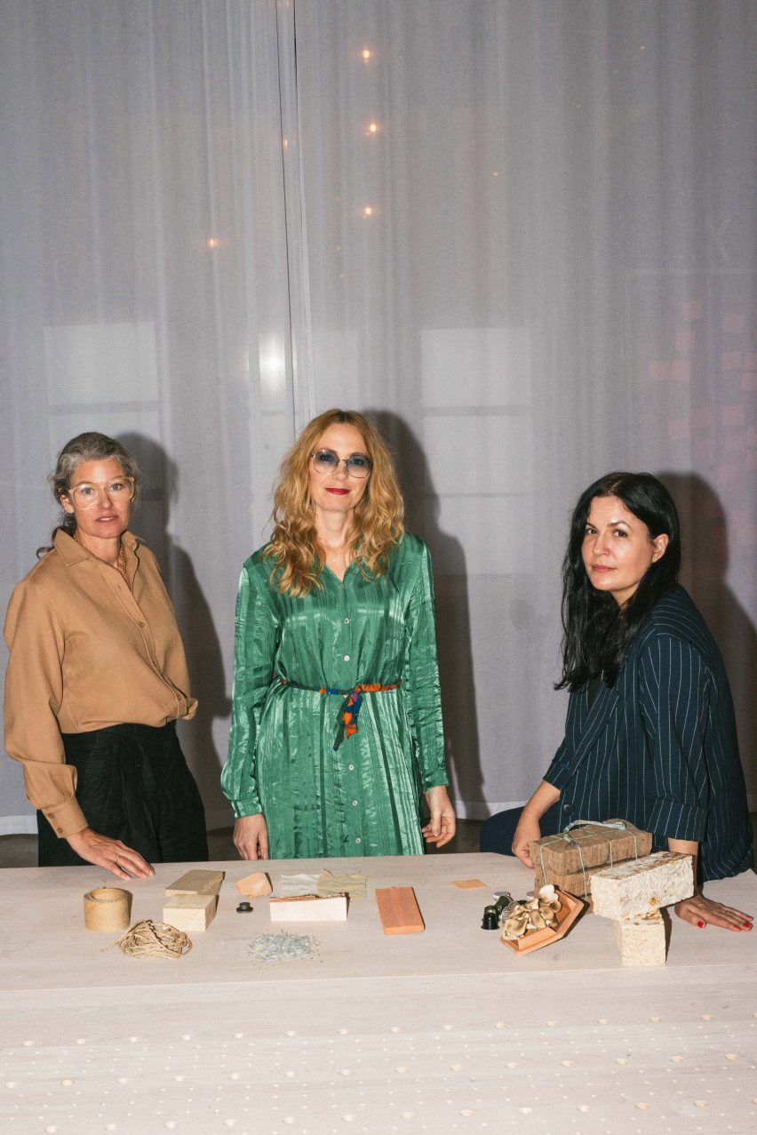 Photo of three people stood at a table