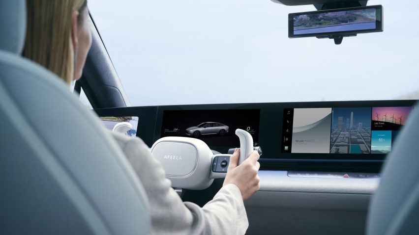 Rear view of woman's hands on a steering wheel