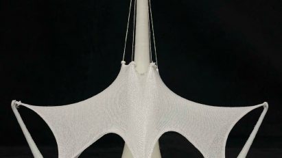 Photograph of white architectural model on black backdrop