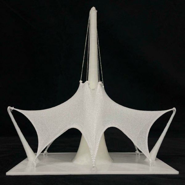 Photograph of white architectural model on black backdrop