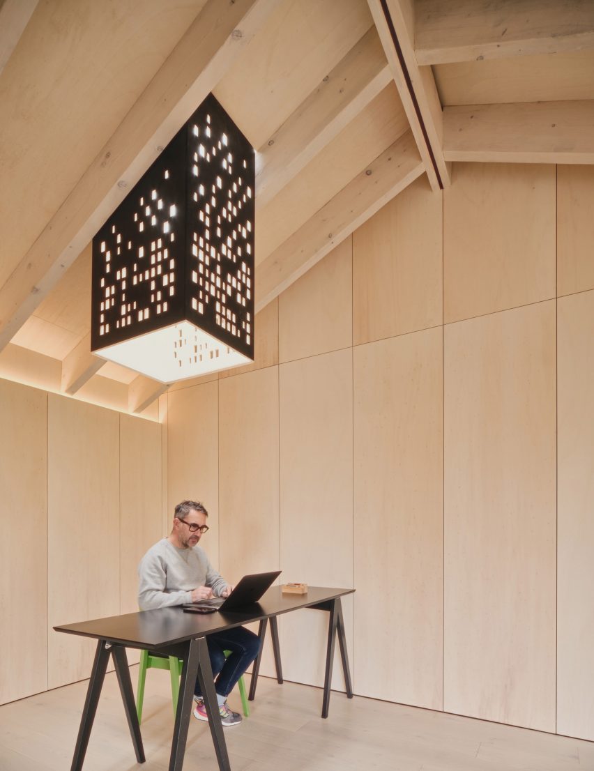 Light chimney and desk in Dark Matter garden studio by Hyper