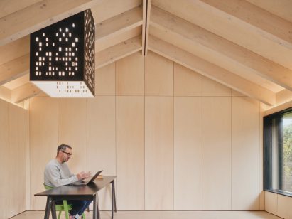 Light chimney and desk in Dark Matter garden studio by Hyper